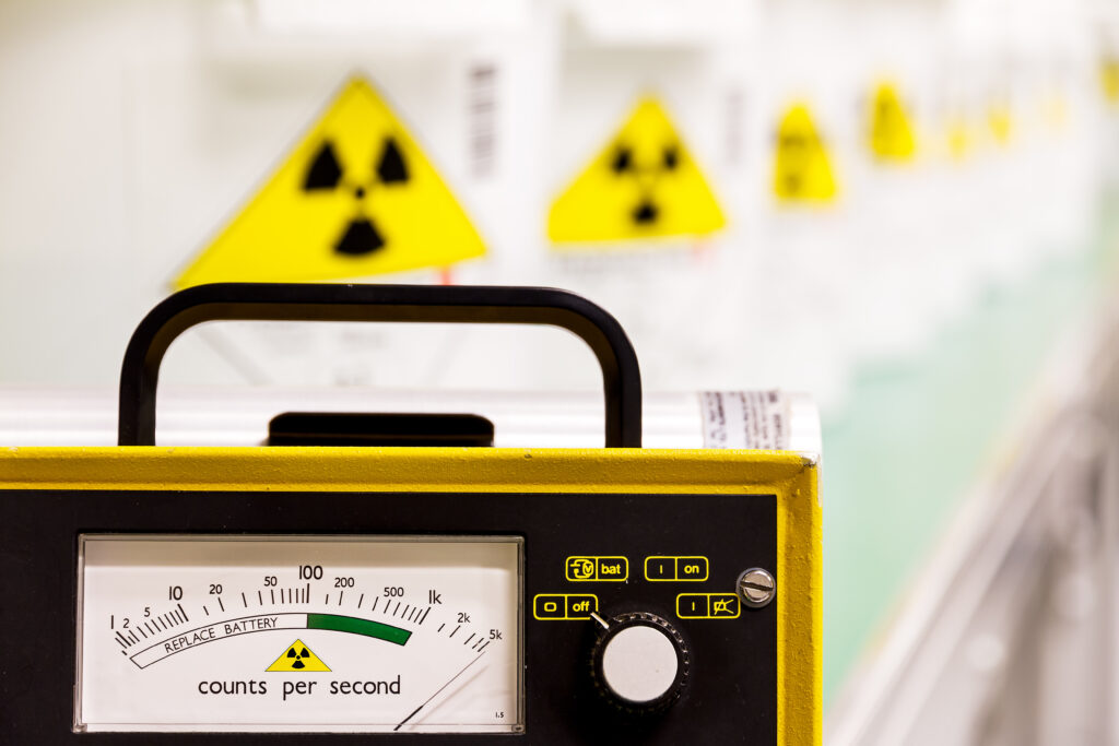 Geiger counter with radioactive materials in the background